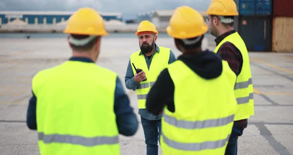 Engineer people controlling shipping containers inside industrial port