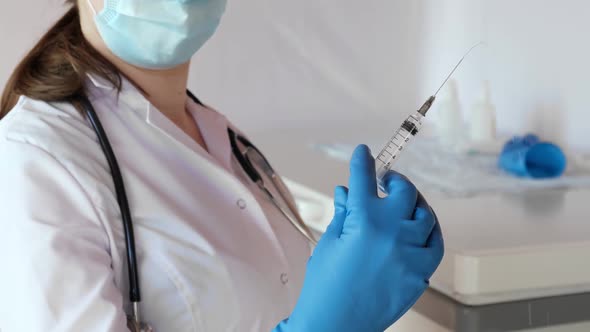 Nurse Holds a Syringe with Medicine in His Hand She Ready to Give an Injection