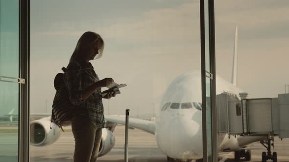 A Silhouette of a Woman with Boarding Documents in Hand