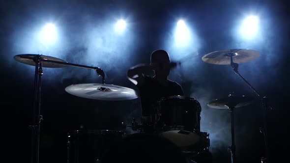 Energetic Music in the Performance of a Professional Drummer. Black Smoky Background. Silhouette