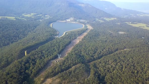 Water reservoir near the Warragamba bushfire zone in Australia with smoke in the distance, Aerial dr