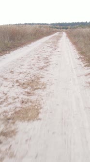 Vertical Video a Dirt Road Through an Empty Field