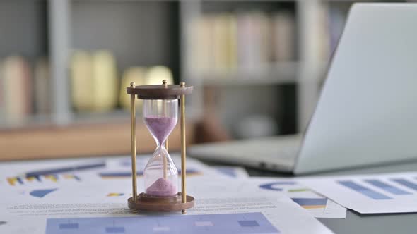Hourglass on Office Desk with Document