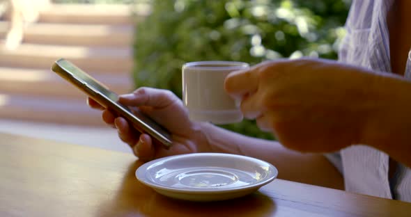 Closeup View of Hands and Face of Woman Drinking Coffee and Typing Sms in Mobile Phone