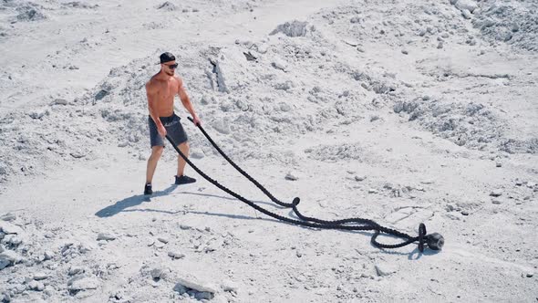 Happy sportsman finishing his workout with battle ropes outdoors