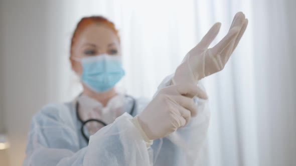 Rack Focus From Female Hands Putting on White Medical Gloves to Face of Professional Woman in