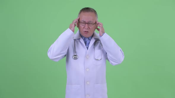 Stressed Mature Japanese Man Doctor Having Headache