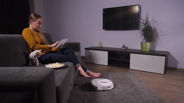 Pretty Woman Relaxing on Sofa with Tablet and Pet