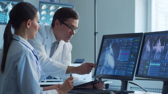 Professional medical doctors working in hospital office making computer research.