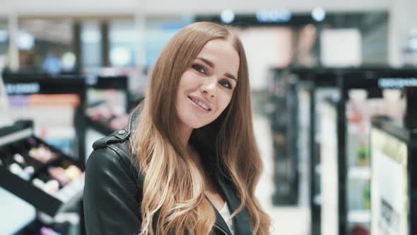 Beautiful Smiling Caucasian Young Woman Posing in a Cosmetics Store