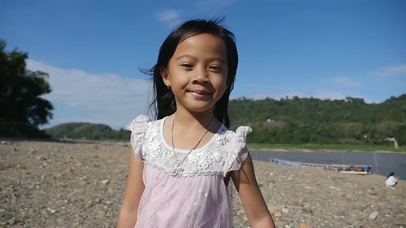 Asian Little Girl Walking Alone Near The River