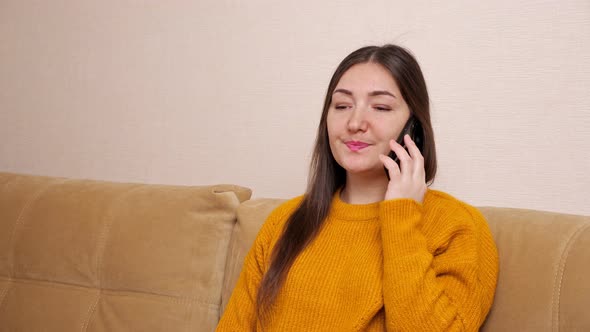 Young Woman with Long Loose Hair Talks on Smartphone at Home