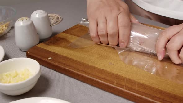 Women's Hands Wrap a Sirloin Roll in a Shell