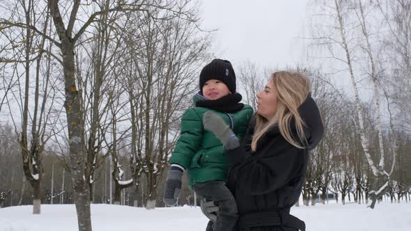 Beautiful Mother Talking to a Child Holding Him in Her Arms