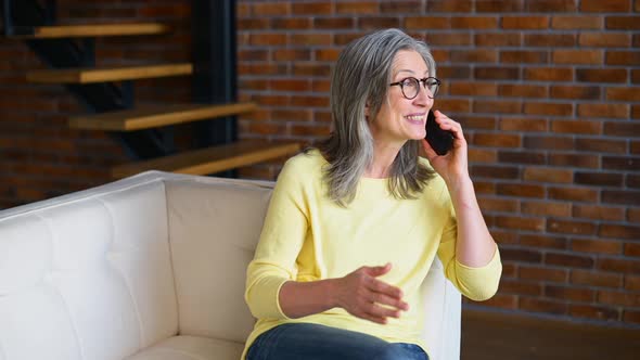 Mature Lady Wearing Casual Wear and Glasses Talking on Smartphone