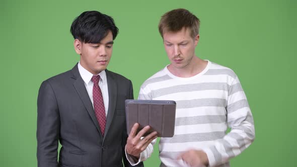 Young Handsome Asian Businessman and Young Scandinavian Businessman Working Together