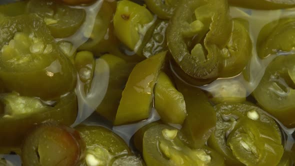 Sliced Pickled Jalapeno Peppers Rotate As Background Closeup of Pickled Chili Jalapeno Peppers