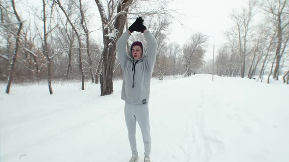 Caucasian Man on Winter Run Runs in Gray Tracksuit with Hood