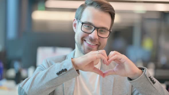 Portrait of Casual Man showing Heart Sign by Hand