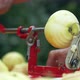 Female Hands Peeling a Green Apple with an Apple Peeler Outdoors - VideoHive Item for Sale