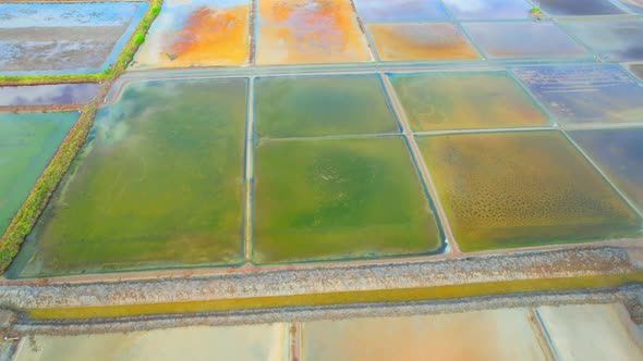 Aerial view flying over a beautiful colorful natural sea salt pond