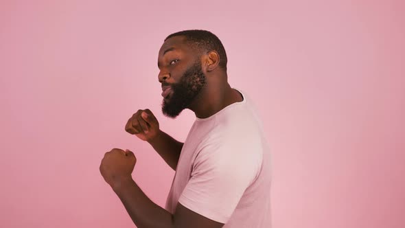 Awesome Millennial African American Man Dancing Enjoying His Activity Pink Studio Background