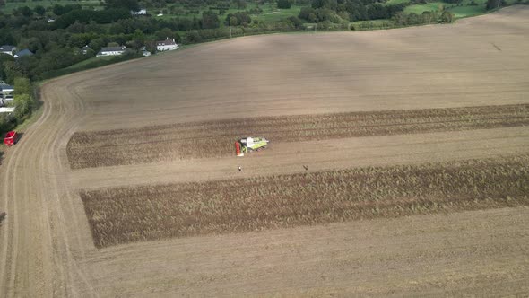 Drone shot of a combine harvester at work in a large field