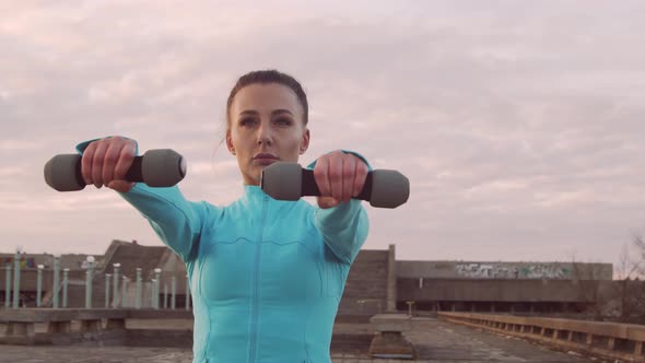 Young, beautiful and sporty woman having evening training outdoor.