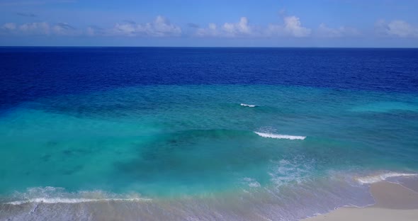 Wide angle flying travel shot of a white sand paradise beach and aqua blue ocean background in best 