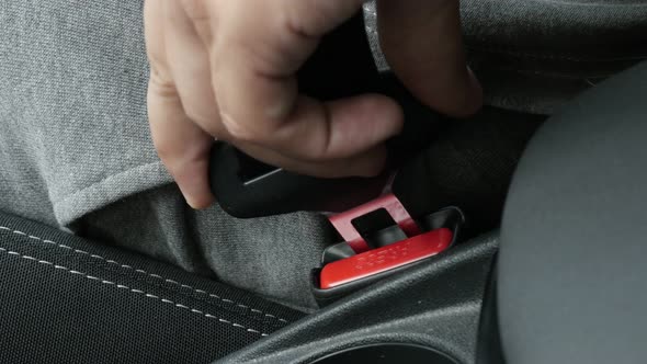 Passenger in car connects 3-point seat  belt on bracket 4K video