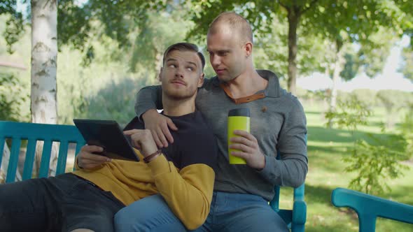 Loving Same-sex Male Couple Resting in Park