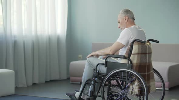 Sad Sorrowful Lonely Old Man Sitting in Wheelchair in His Ward of Nursing House