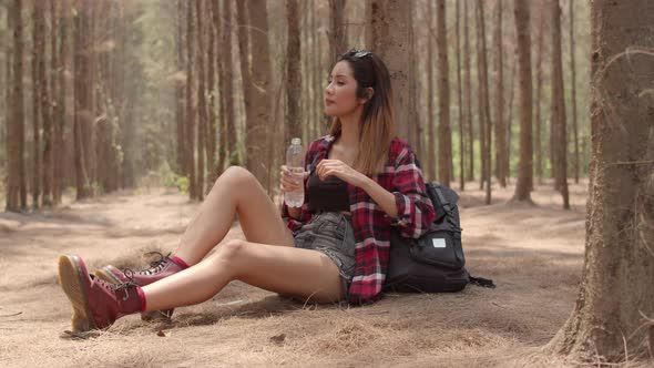 Young happy backpack girl rest drink water from bottle after walk travel nature adventure trip