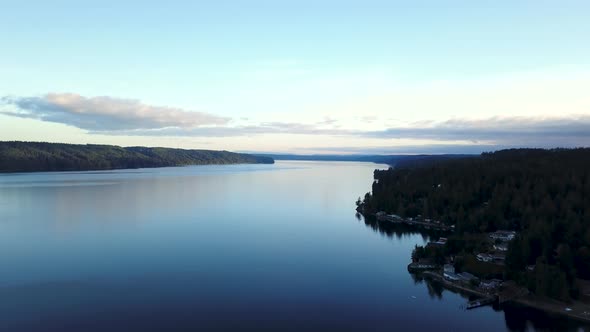 Aerial flying over nice houses next to the Hood Canal in Washington at sunset.