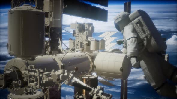 International Space Station and Astronaut in Outer Space Over the Planet Earth alt