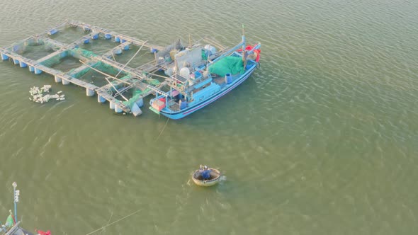 Drone view of fisherman sailing on a basket boat to the fish farm, Nha Trang city, Khanh Hoa provinc