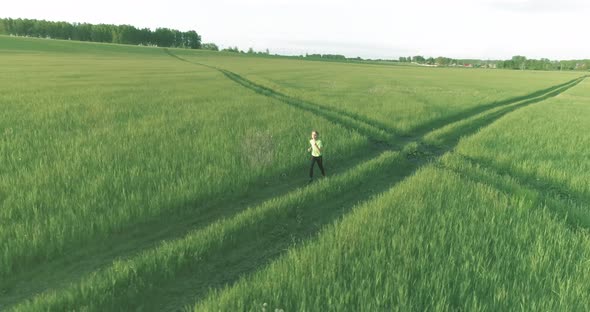 Sporty Child Runs Through a Green Wheat Field