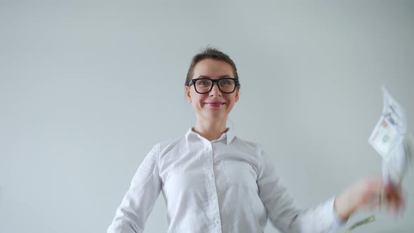 Happy Woman with Glasses Making Money Rain From Dollar Bills