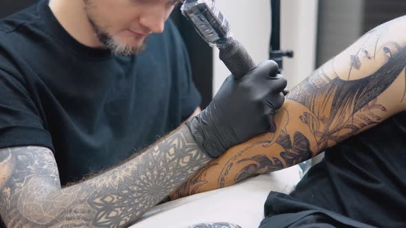 The Process of Tattooing a Man's Hand in a Tattoo Parlor