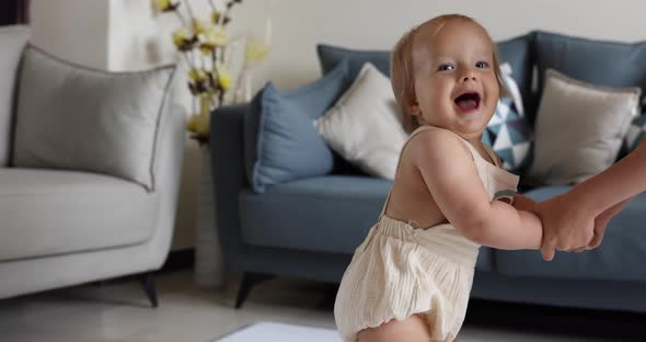 Cute Caucasian Baby Girl with Blonde Hair and Blue Eyes One Year Old Learning Walk