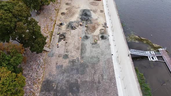 People working in riverside archeological digsite, flying over view