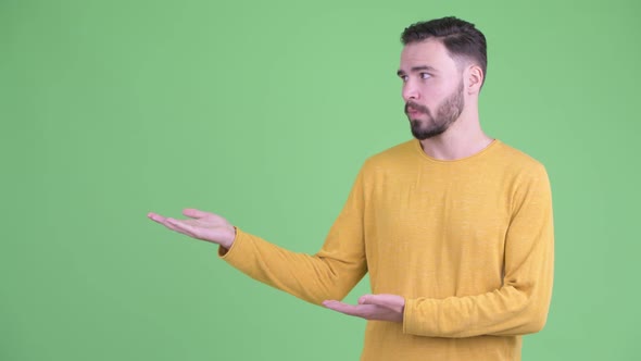 Stressed Young Bearded Man Showing Something