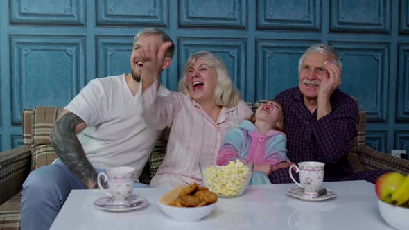 Multigenerational Happy Family Laughing Watching Cartoons Television Movies Showing Thumbs Down