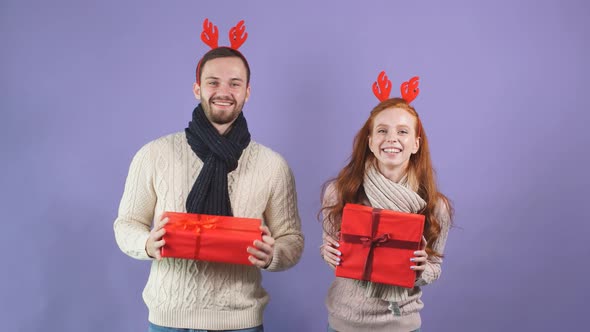 Studio Portrait of Happy Young Family with Christmas Gifts.