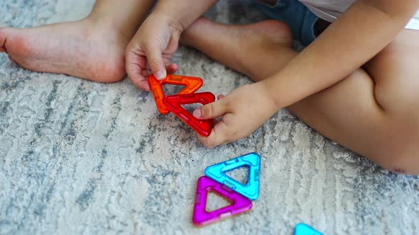 Little Girl Playing Colorful Magnet Plastic Blocks Kit at Home