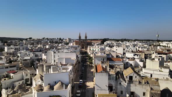 Aerial drone shot flying to a cathedral in Alberobello, Italy.