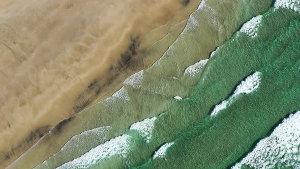 Vertical view on the Norwegian sand beach and sea waves