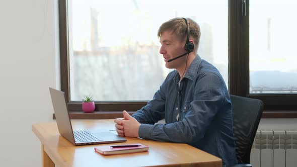 man wear wireless headphones making video conference business call on laptop speaking 
