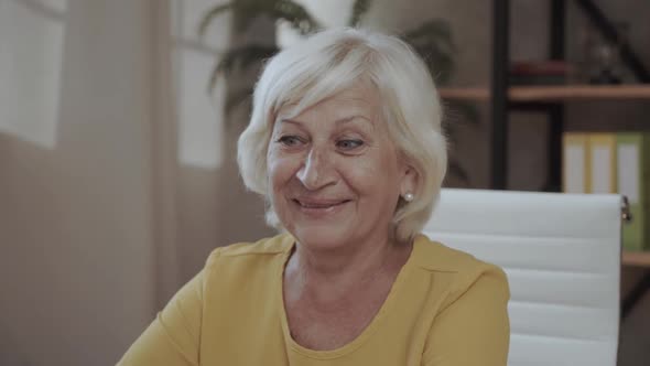 Portrait Elderly Happy Woman Takes Off Glasses and Smiles. Looking at the Camera