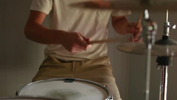 Drummer practicing rudiments on his drum kit.